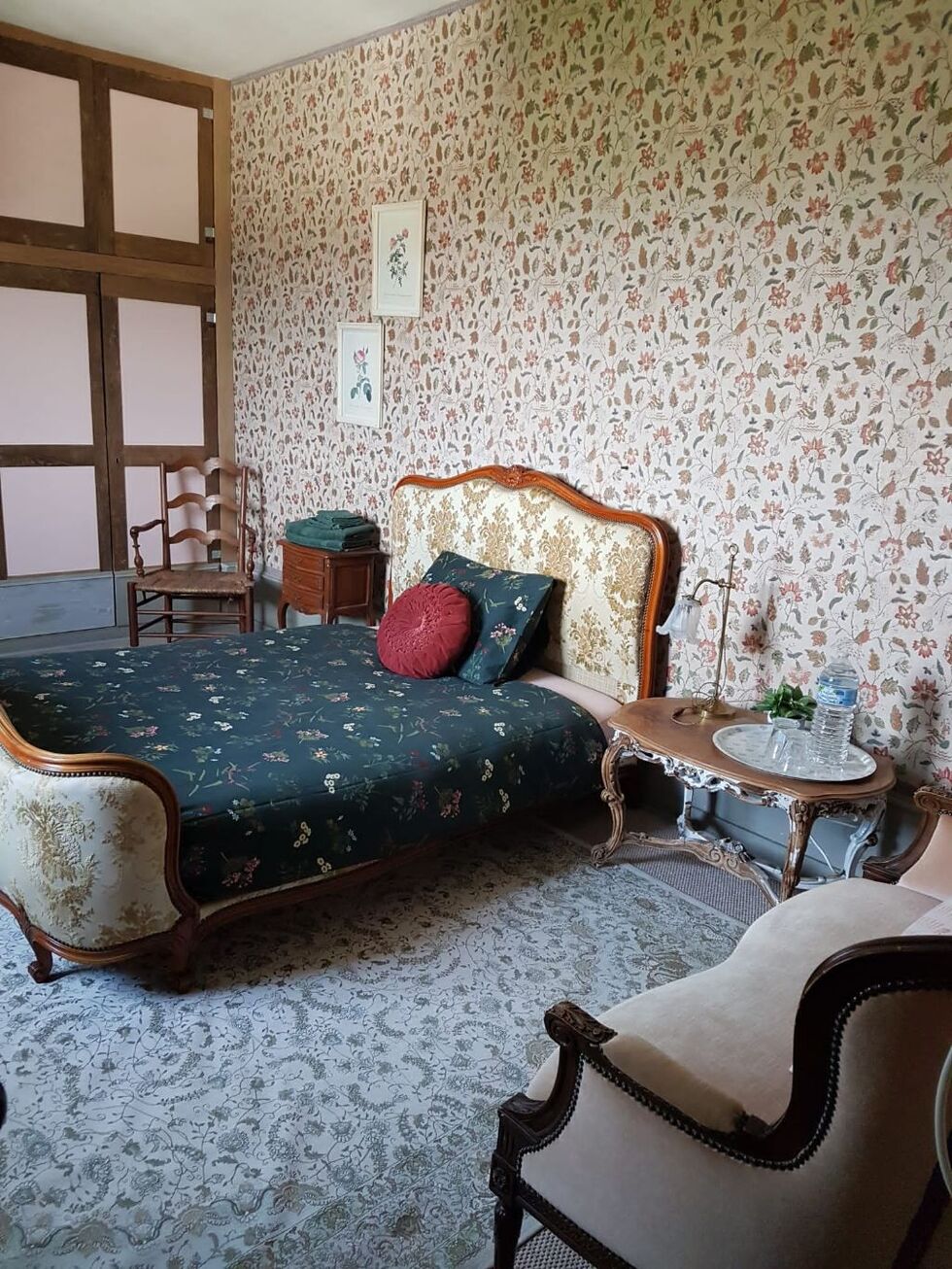 Gastenkamer met antiek bed en gebloemd behang