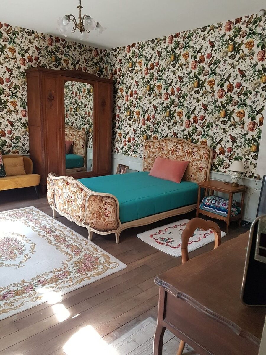 Gastenkamer met antiek bed en vogelbehang