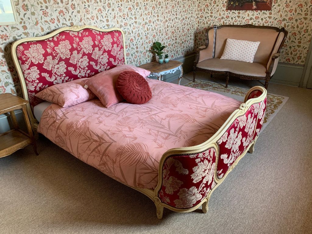 Antiek bed met rood damast in een van de gastenkamers